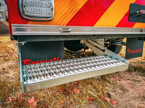 Rear bumper step close-up with chevron panel and metal tread plate.