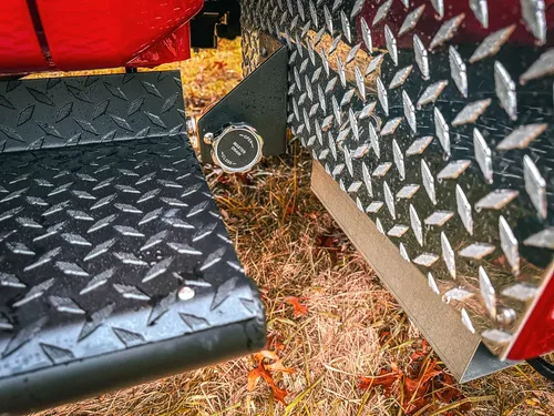 Diamond-plate side step close-up with key cylinder and trim.
