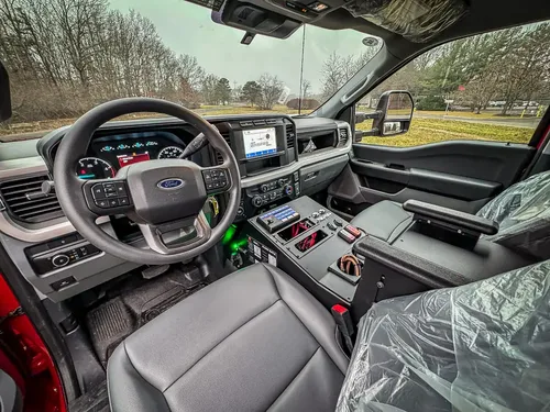 Front cabin interior view with steering wheel and center console.