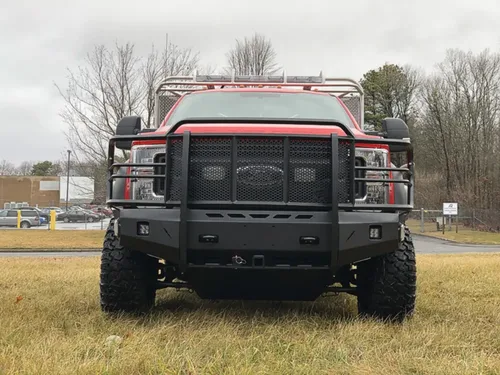 Exterior view of small fire truck showing cab, body compartments, and wheel/tire area.