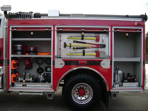 Exterior view of small fire truck showing cab, body compartments, and wheel/tire area.