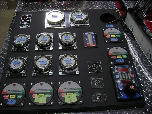 Exterior view of small fire truck showing cab, body compartments, and wheel/tire area.