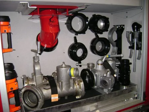Exterior view of small fire truck showing cab, body compartments, and wheel/tire area.