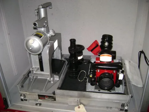 Exterior view of small fire truck showing cab, body compartments, and wheel/tire area.