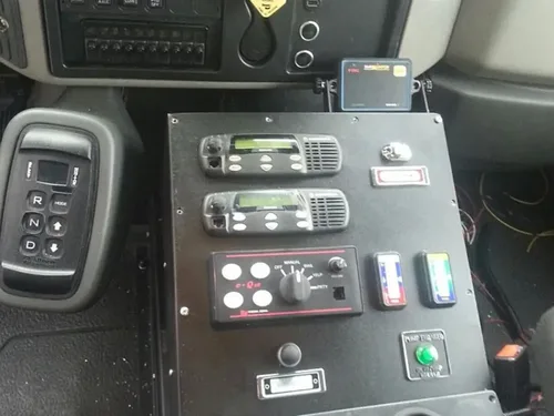 Exterior view of small fire truck showing cab, body compartments, and wheel/tire area.
