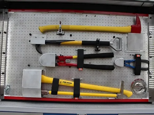 Exterior view of small fire truck showing cab, body compartments, and wheel/tire area.