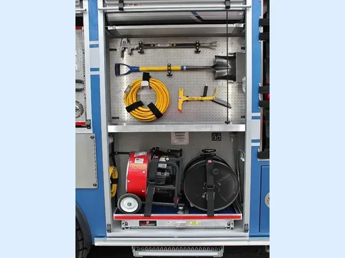 Exterior view of small fire truck showing cab, body compartments, and wheel/tire area.