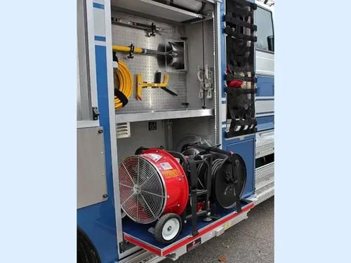 Exterior view of small fire truck showing cab, body compartments, and wheel/tire area.