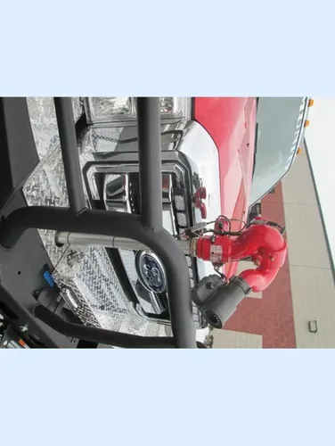 Exterior view of small fire truck showing cab, body compartments, and wheel/tire area.