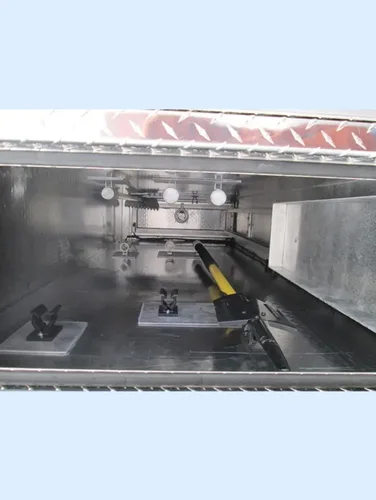 Exterior view of small fire truck showing cab, body compartments, and wheel/tire area.