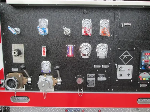 Exterior view of small fire truck showing cab, body compartments, and wheel/tire area.