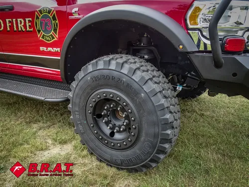 Front wheel and fender close-up showing off-road tire and suspension clearance.