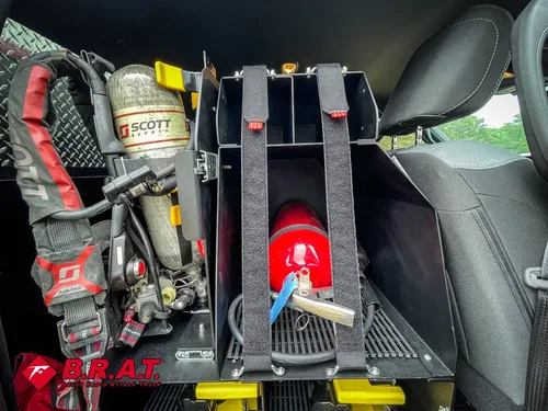 Mounted gear rack close-up beside rear seat with extinguisher and tools.