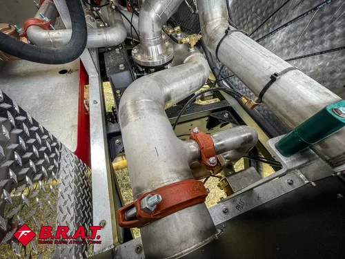 Pump compartment corner close-up with exhaust-like tubing and valve hardware.