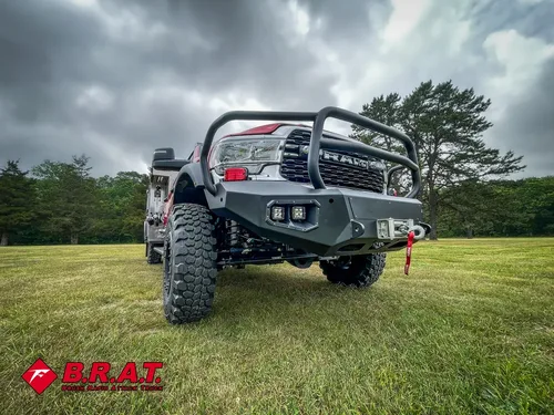 Low front-left angle emphasizing bumper, brush guard, and front tire.