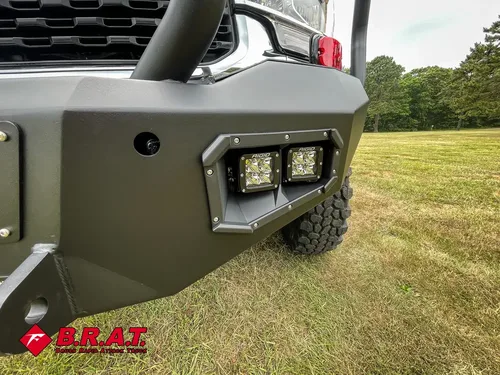 Front bumper side close-up with mounted auxiliary lights.
