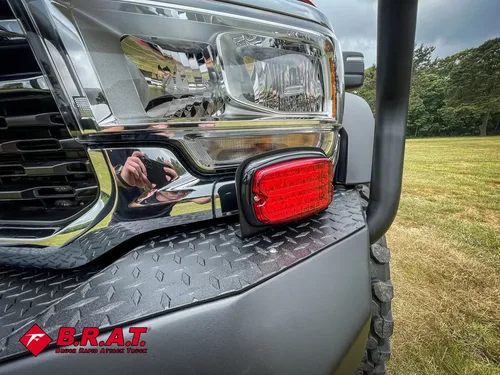 Headlight and bumper corner close-up with red marker light.