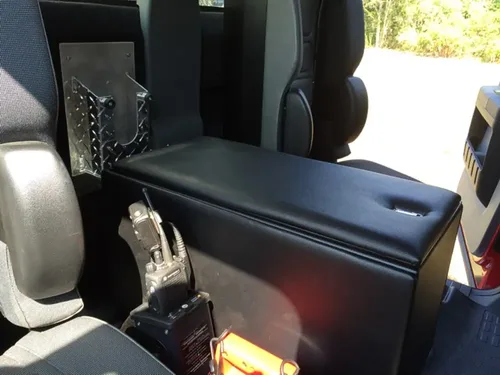 Exterior view of small fire truck showing cab, body compartments, and wheel/tire area.
