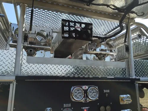 Exterior view of small fire truck showing cab, body compartments, and wheel/tire area.
