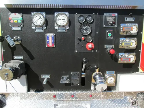Exterior view of small fire truck showing cab, body compartments, and wheel/tire area.