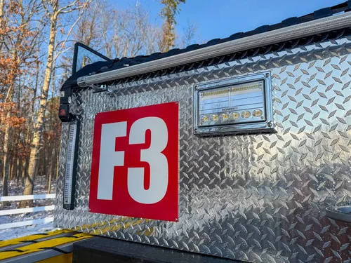 Close-up of rear upper body with F3 marking, warning strip, and scene light.