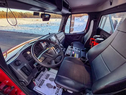Interior cab view showing rear wall flashlights, seating, and center console panel.