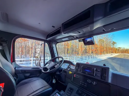 Interior cab view from passenger side showing dash, steering wheel, and overhead storage.