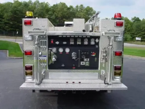 Exterior view of small fire truck showing cab, body compartments, and wheel/tire area.
