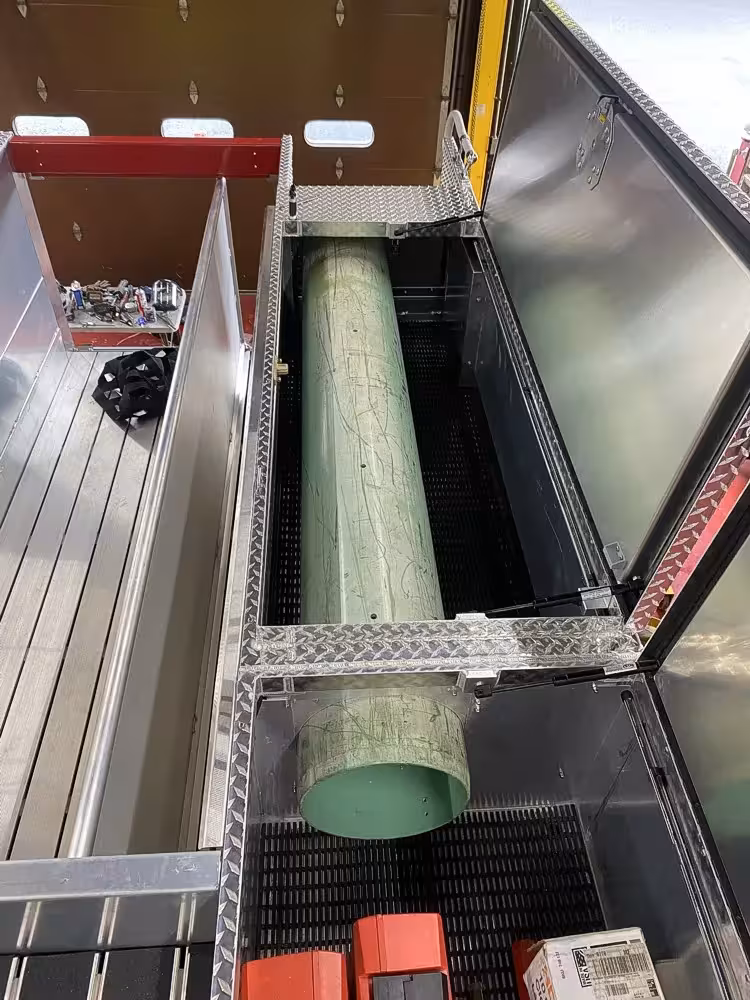 Open upper side compartment showing long cylindrical tube in narrow storage channel