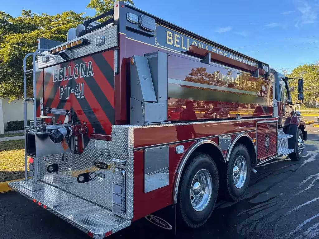 Rear-left exterior view showing tanker body, tandem axles, and rear compartments