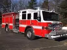 Wide front right view of the parked pumper showing bumper, cab, and full side body.