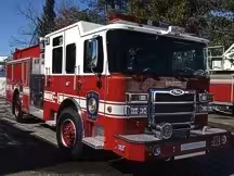 Wide front-right view of the pumper parked in the lot with full side body visible.