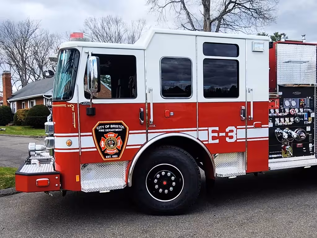 Cab-side close-up showing city crest, side windows, and front wheel area