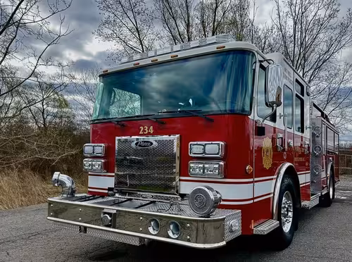 Pumper front view showing grille, headlights, and bumper-mounted siren