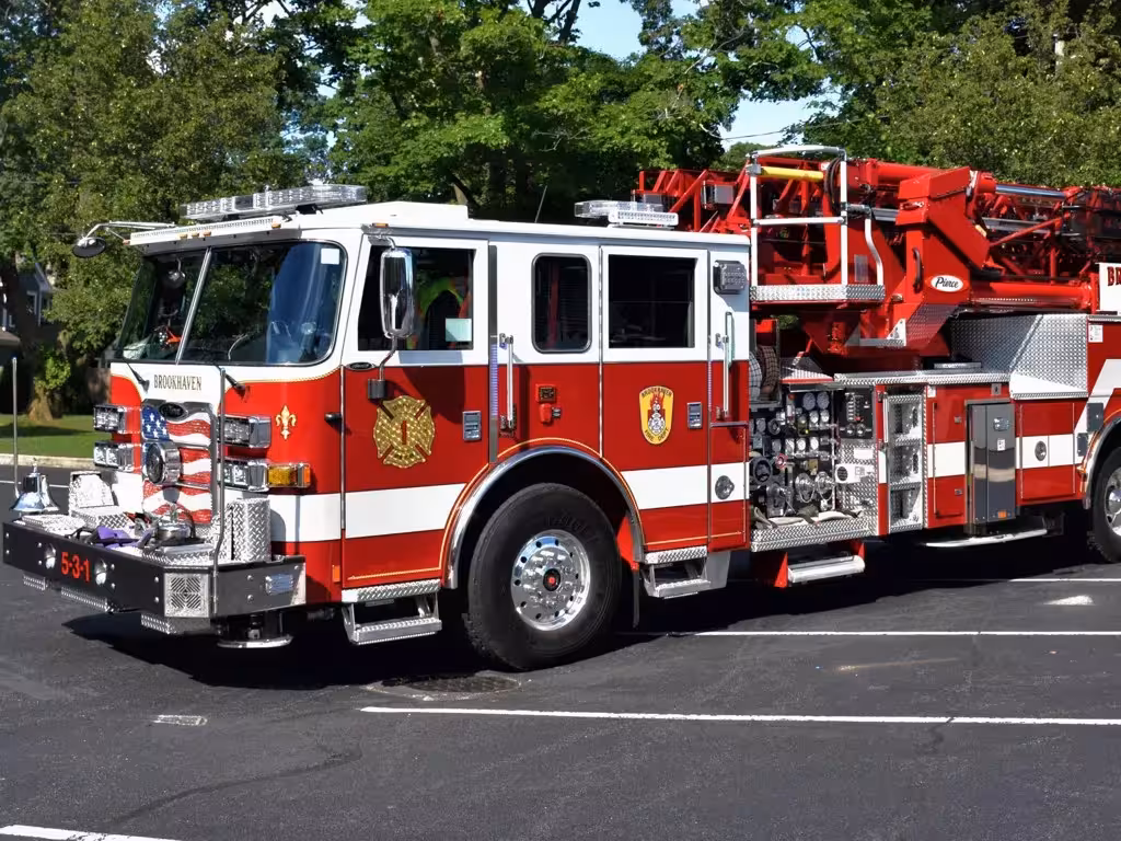 Tower ladder truck front-left exterior view showing ladder base and cab