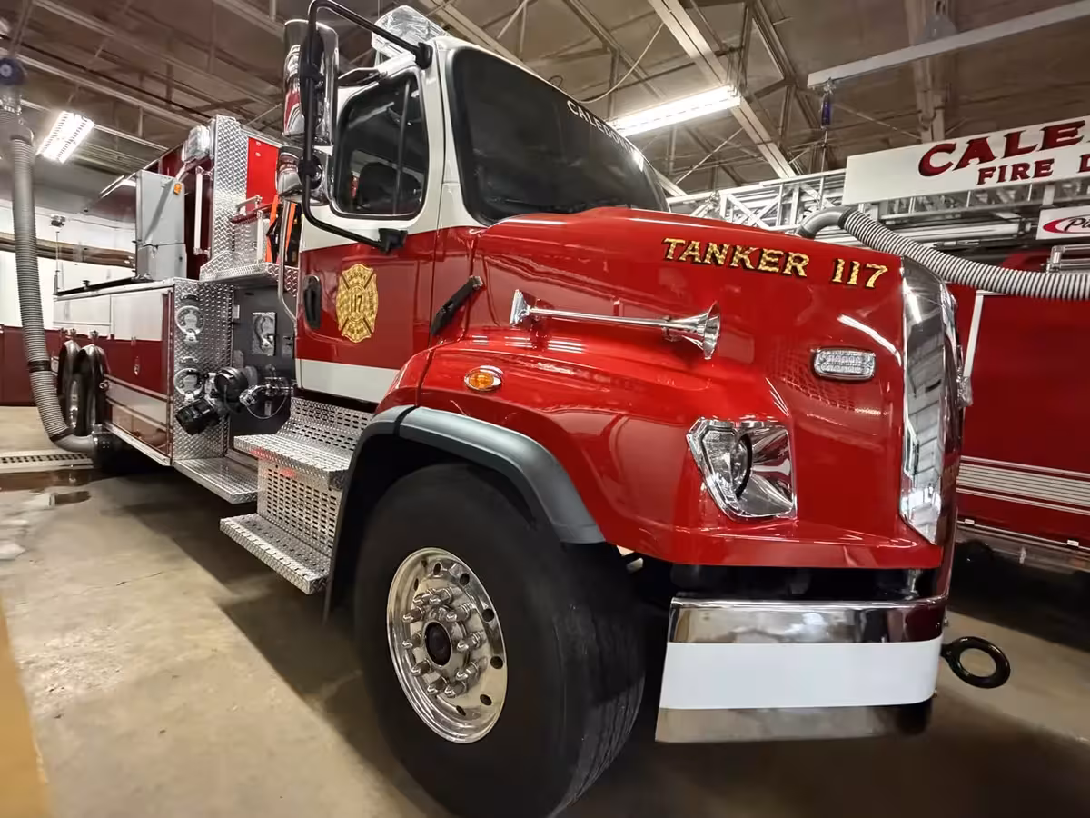 Tanker front-right exterior view in apparatus bay showing side pump panel and wheel area