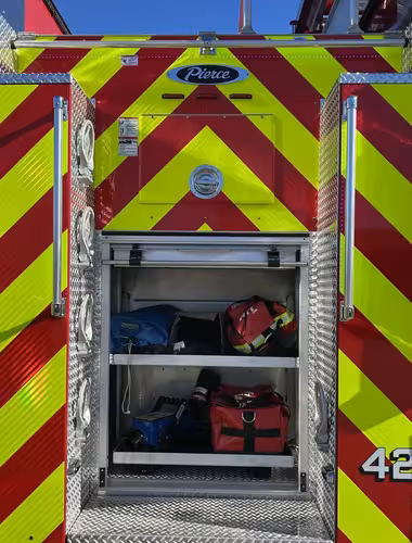 Pierce pumper rear-right exterior view with chevron striping and open rear bay
