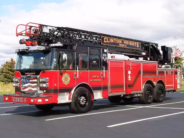 Tower ladder truck front-left exterior view showing ladder sections and cab