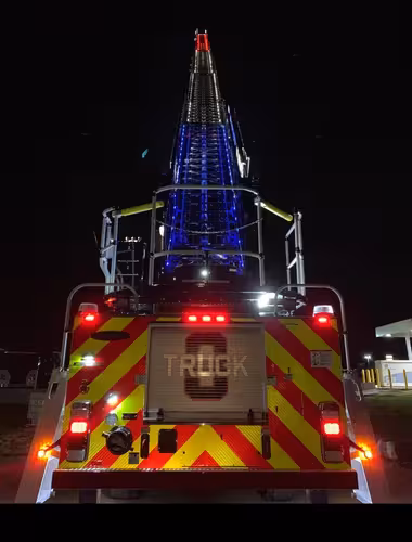 Night rear view showing illuminated chevrons and ladder tip with lights