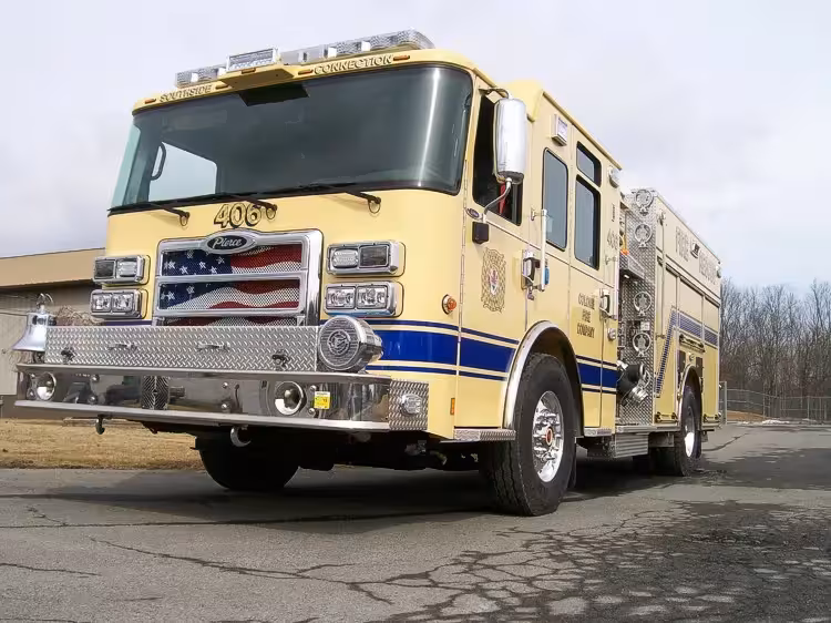 Rescue pumper front-left exterior view showing enclosed cab and side compartments