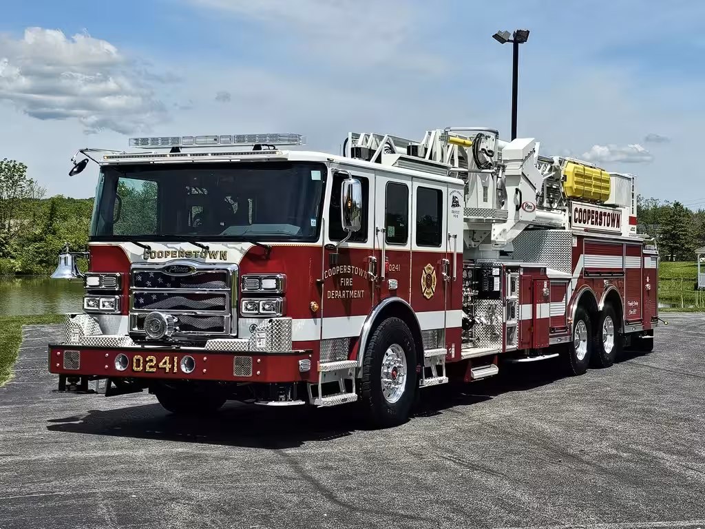 Aerial ladder truck front-left exterior view showing enclosed cab and ladder bed