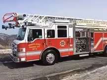 Tower ladder front-left exterior view showing enclosed cab and aerial sections
