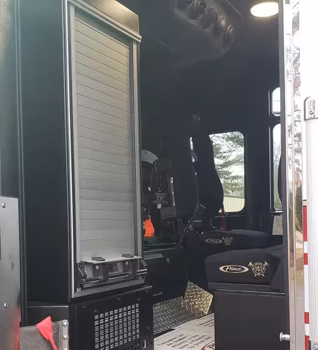 Open rear cab door view showing walk-through access and seat area