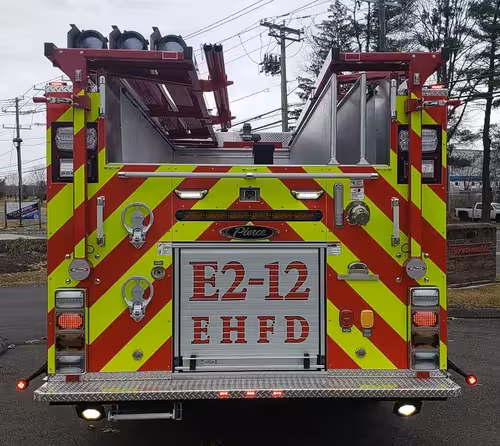Rear view showing red-and-yellow chevrons and raised unit lettering