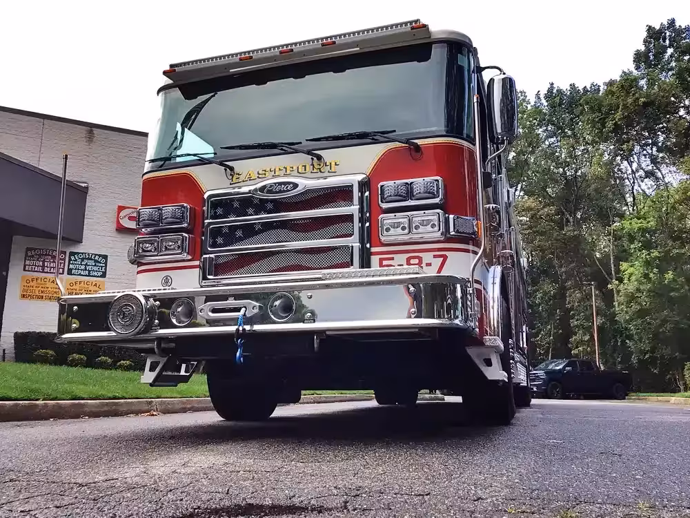 Pumper front-left exterior view showing chrome bumper, cab, and side body