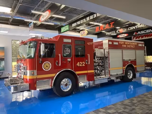 Pumper driver-side profile indoors showing side compartments and pump panel area