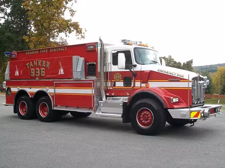 Driver-side profile view of a tanker with commercial cab, side compartment doors, and tandem rear axles.