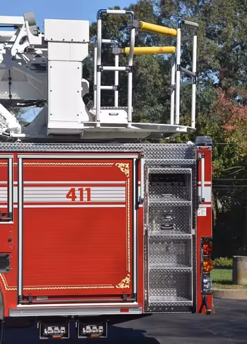 Rear body close-up showing ladder access platform and rear compartment stack