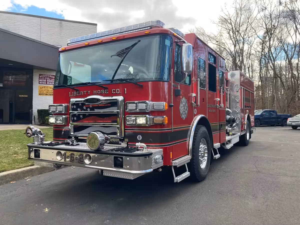 Pumper front-right exterior view showing cab, grille, and pump-panel side body