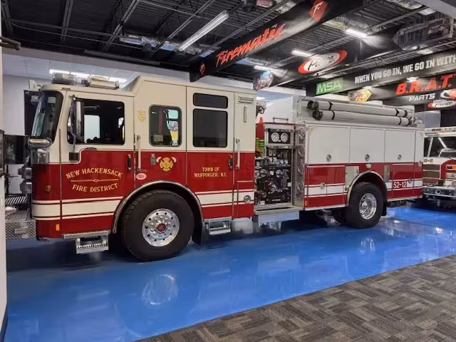 Pumper driver-side profile indoors showing side compartments and wheel area
